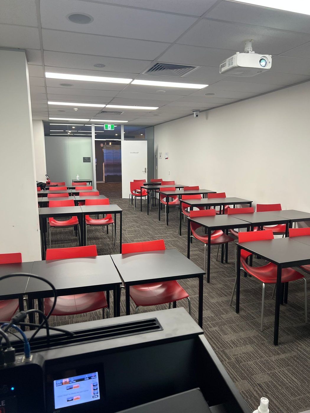 The Vertex Mathematics teaching room set up with desks, chairs and a projector