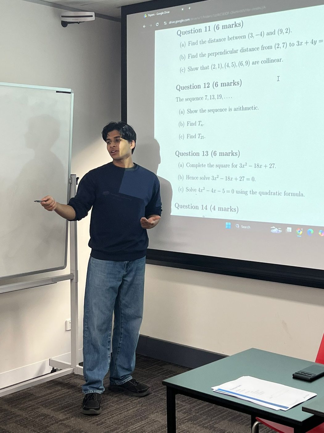 A Vertex tutor teaching a class in front of the display